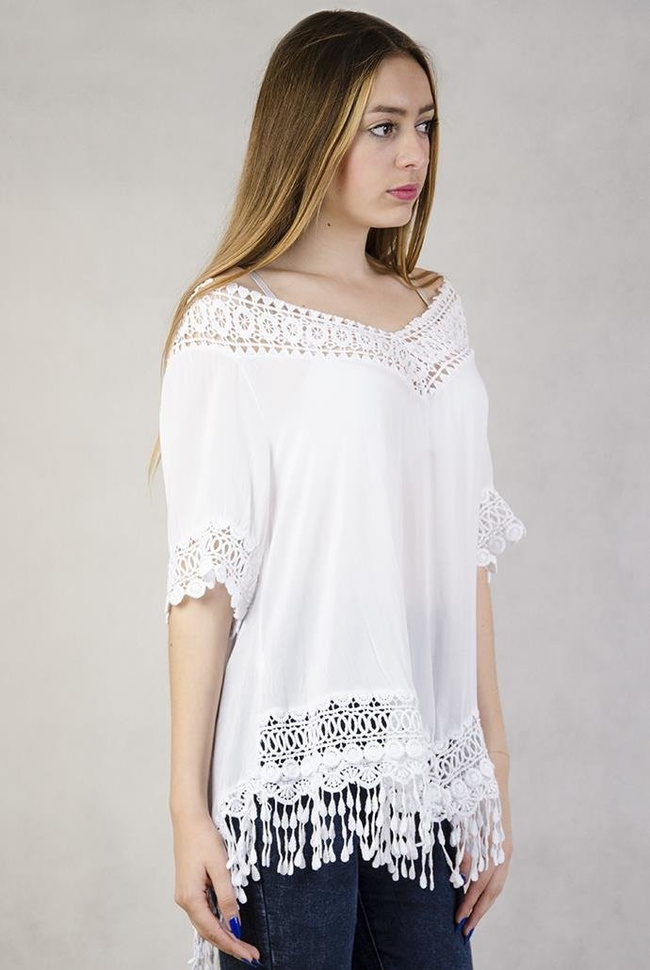 Biała, asymetryczna bluzka z ażurowymi zdobieniami i frędzelkami