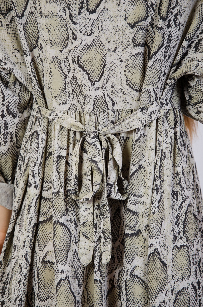 Zielona sukienka w serek wiązana w pasie