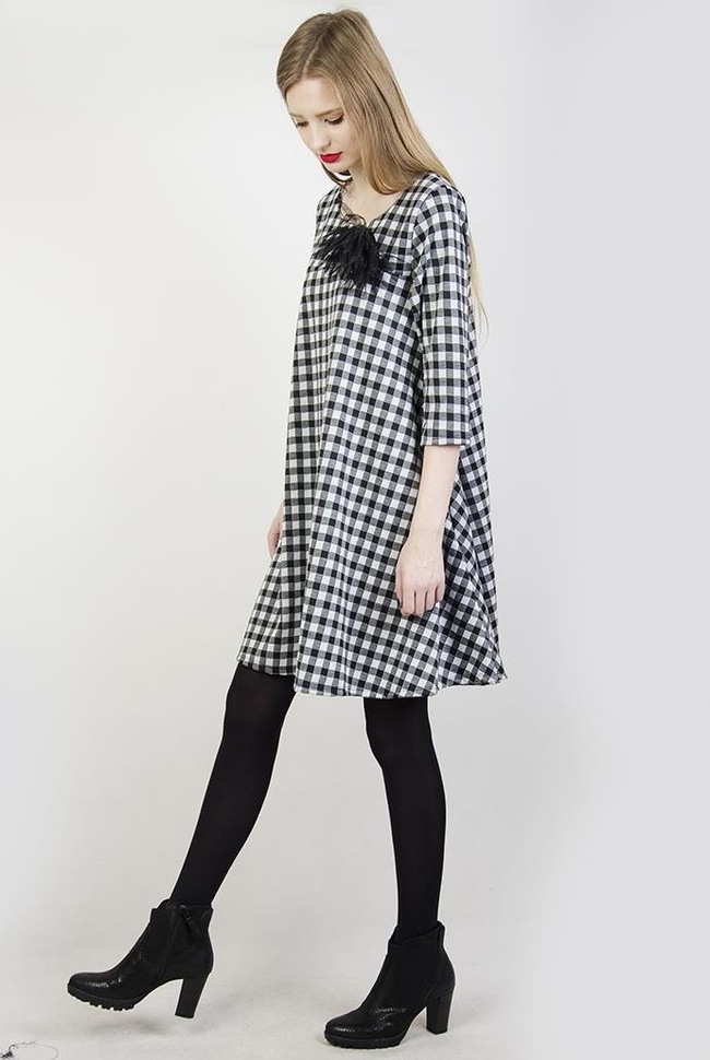 Rozkloszowana biało-czarna sukienka w kratę z broszką