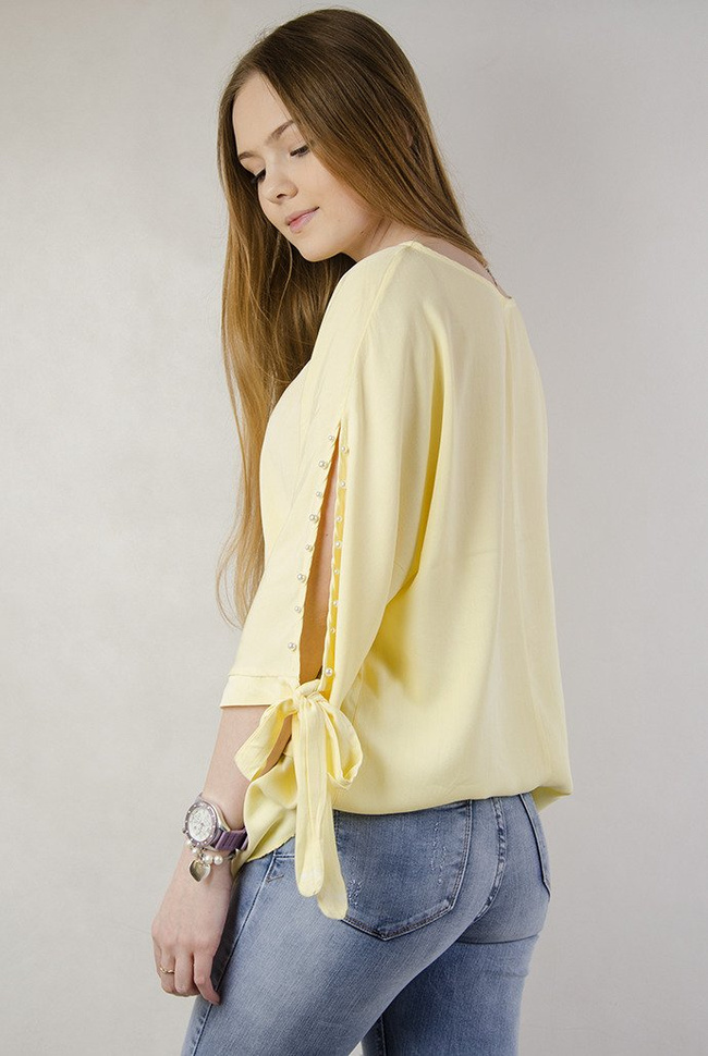 Żółta asymetryczna bluzka z wiązaniem przy rękawie oraz perełkami