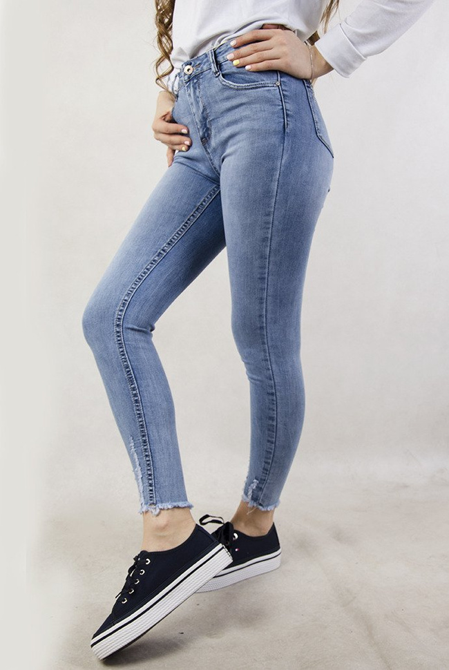 Jasne spodnie jeansowe z szarpaniem przy nogawce