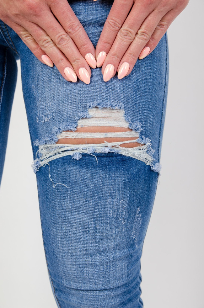 Jasne spodnie jeansowe z dużymi szarpaniami