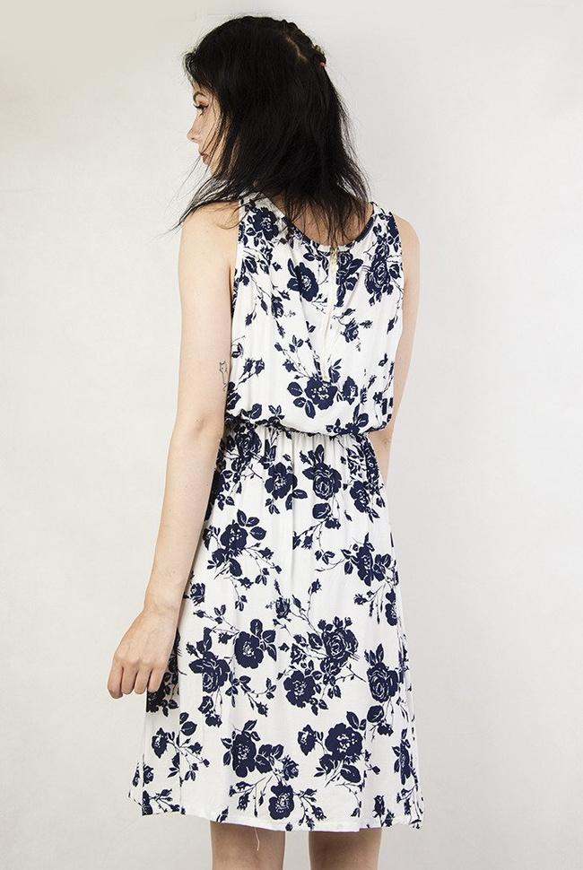 Biała sukienka w granatowe kwiaty z zamkiem z tyłu, zakończonym perłą.