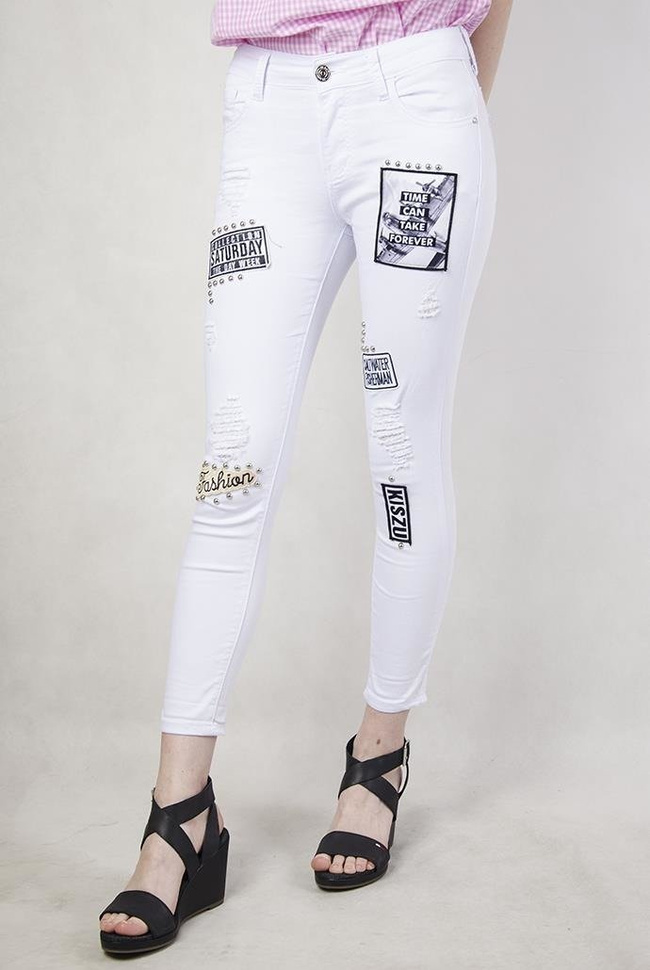 Białe spodnie jeansowe z naszywkami i dziurami