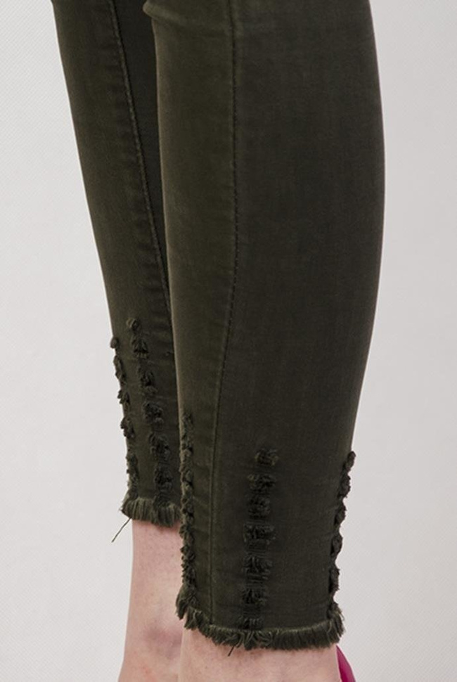 Zielone spodnie jeansowe z przetarciami przy nogawce