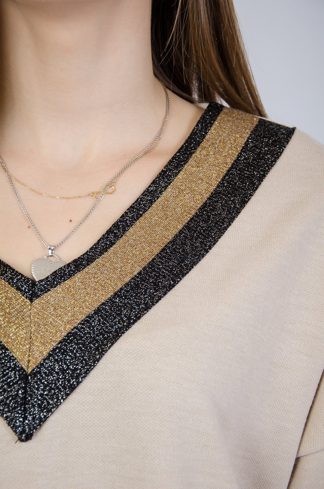 Beżowa sukienka zakończona brokatowymi elementami z kieszeniami