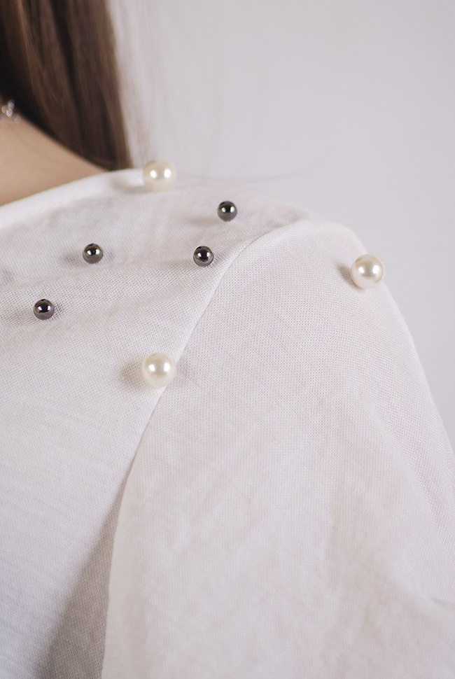 Biała bluzka z wycięciem na plecach oraz koralikami na ramionach