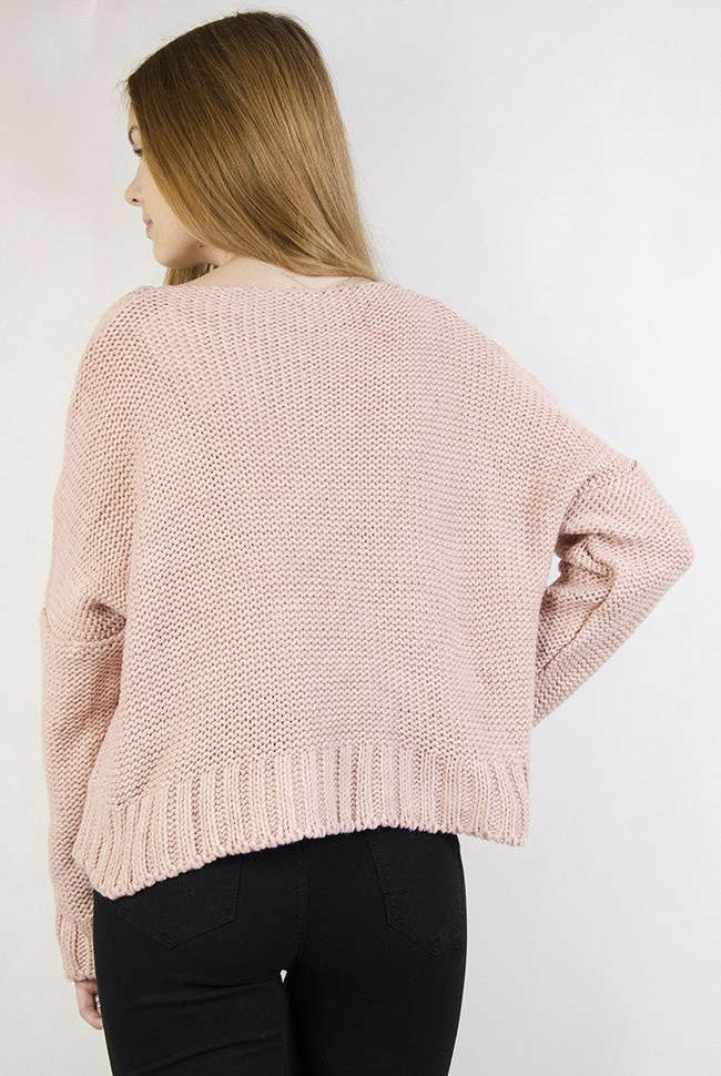 Krótki różowy sweter z przeplatanymi warkoczami.