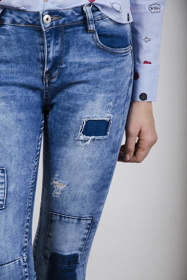 Spodnie jeansowe z ciemnymi łatami i przeszyciami