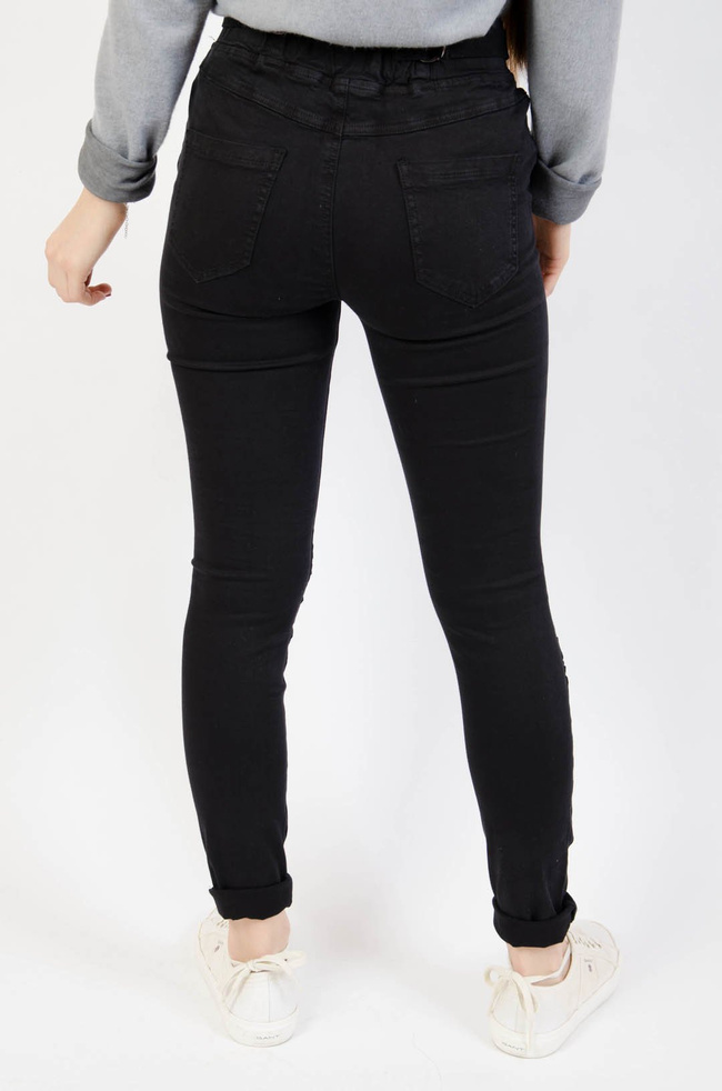 Czarne spodnie jeansowe z gumą w pasie oraz marszczeniem na kolanach