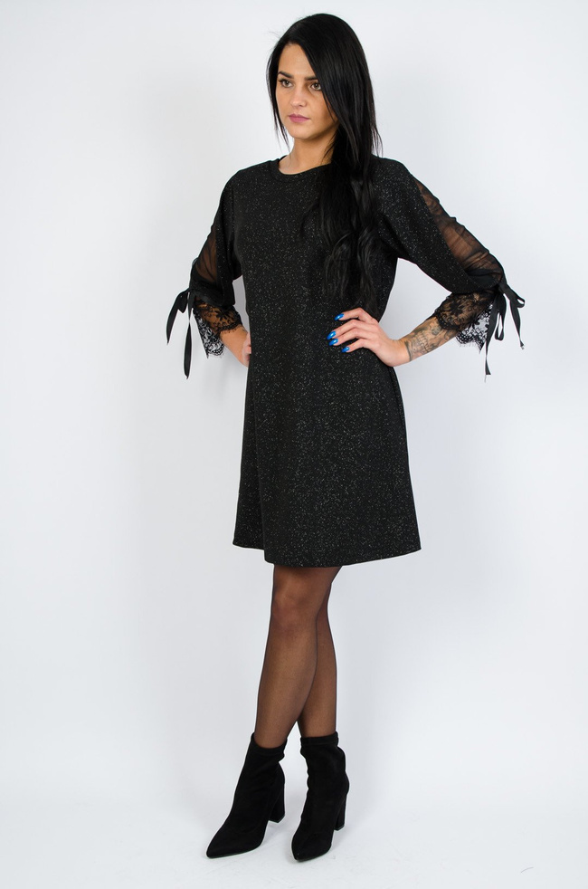 Czarna sukienka pokryta brokatem z koronką przy rękawach