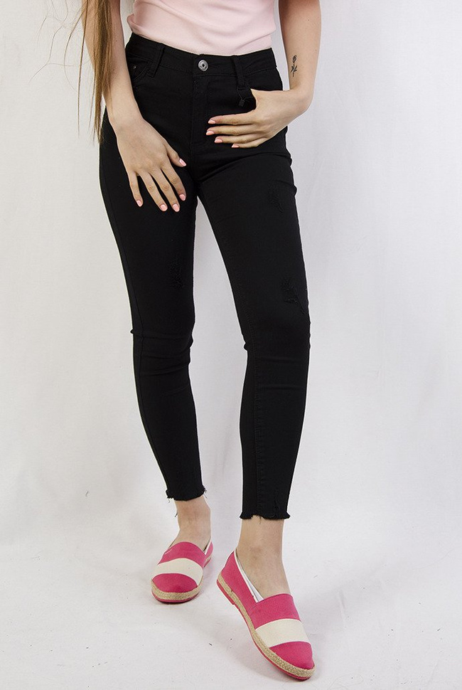 Czarne spodnie z przetarciami oraz szarpaniem przy nogawce