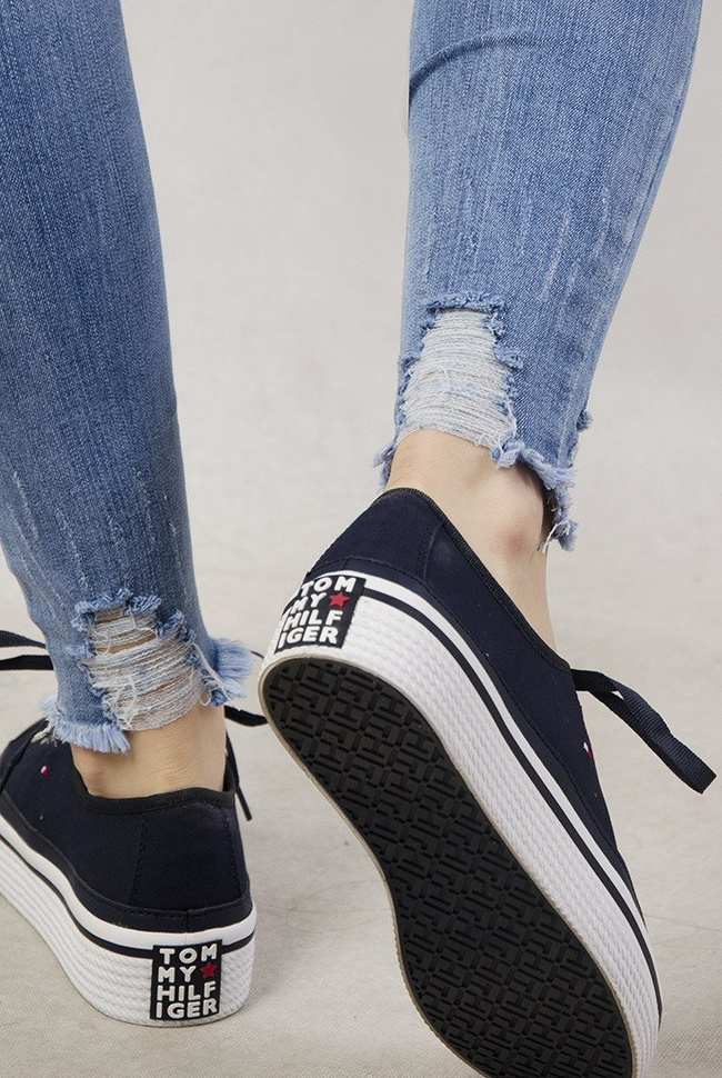 Jasne spodnie jeansowe z dziurami oraz przetarciami