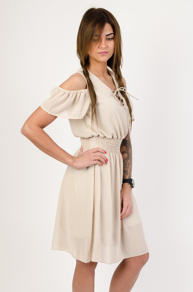 Beżowa sukienka z wiązaniem w dekolcie oraz gumą w pasie