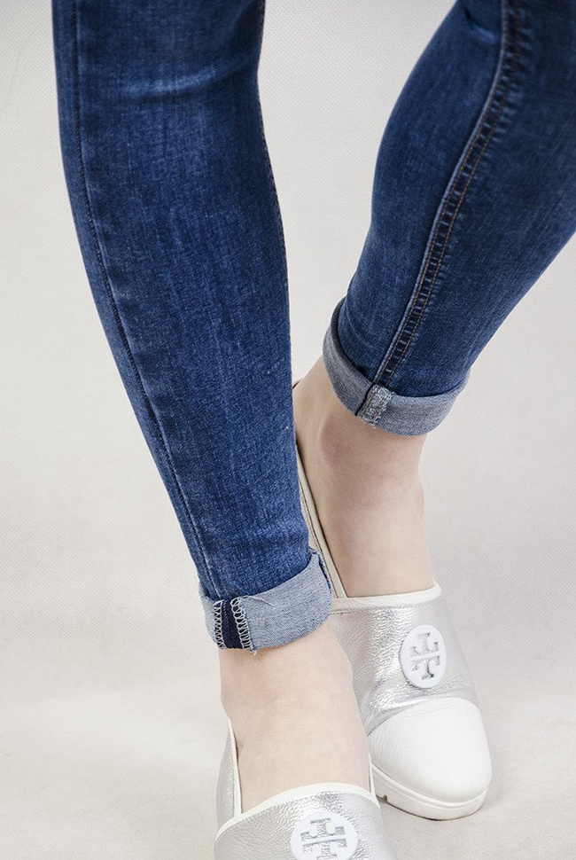 Spodnie jeansowe z przetarciami oraz wywijaną nogawką