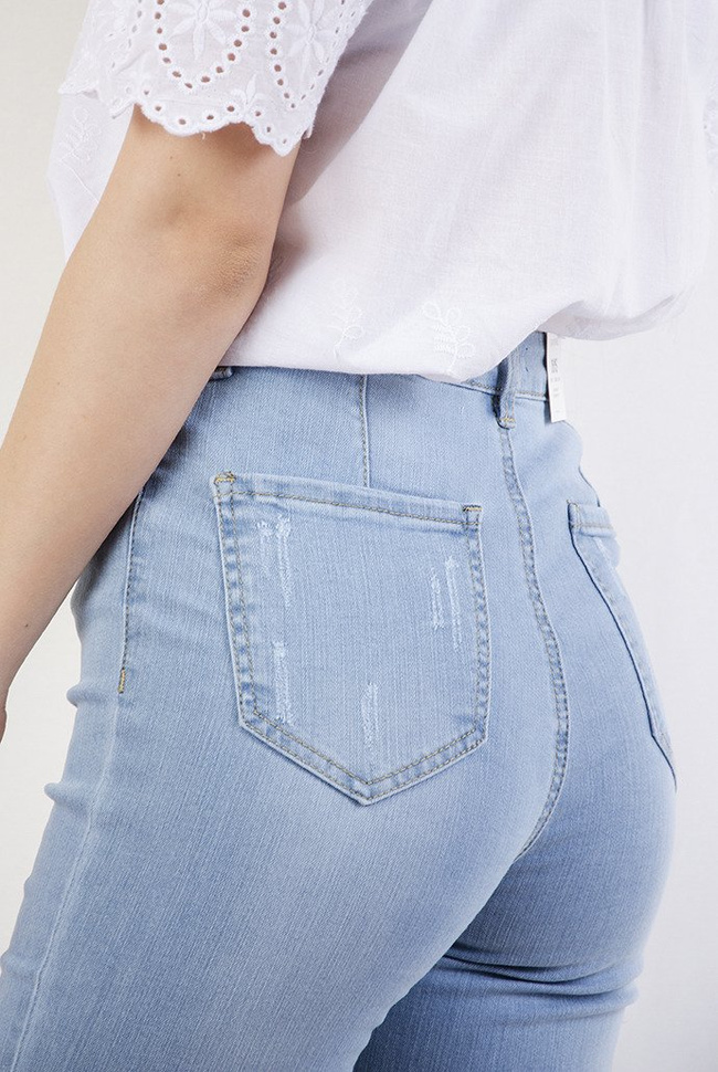 Jasne spodnie jeansowe z dużymi przetarciami