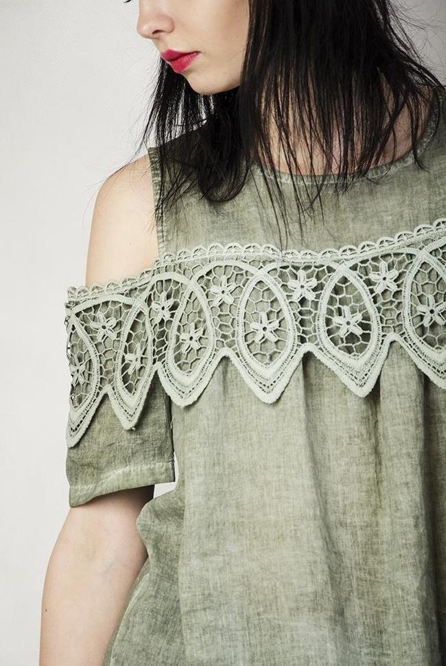 Zielona bluzka z wyciętymi ramionami i ażurowym zdobieniem