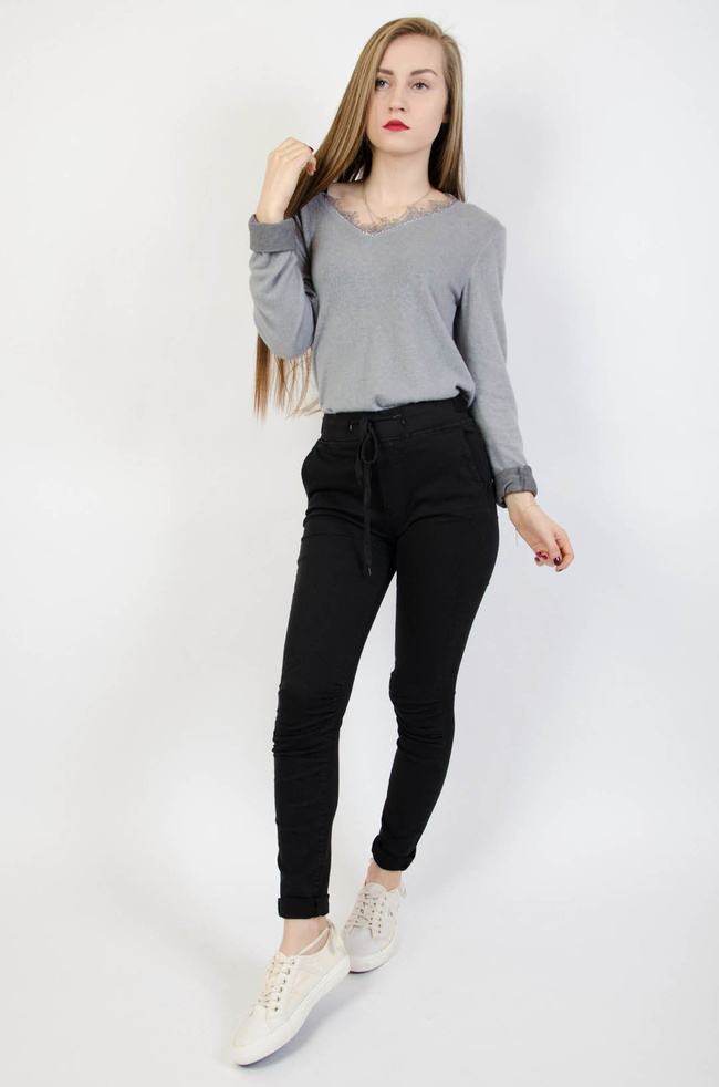 Czarne spodnie jeansowe z gumą w pasie oraz marszczeniem na kolanach