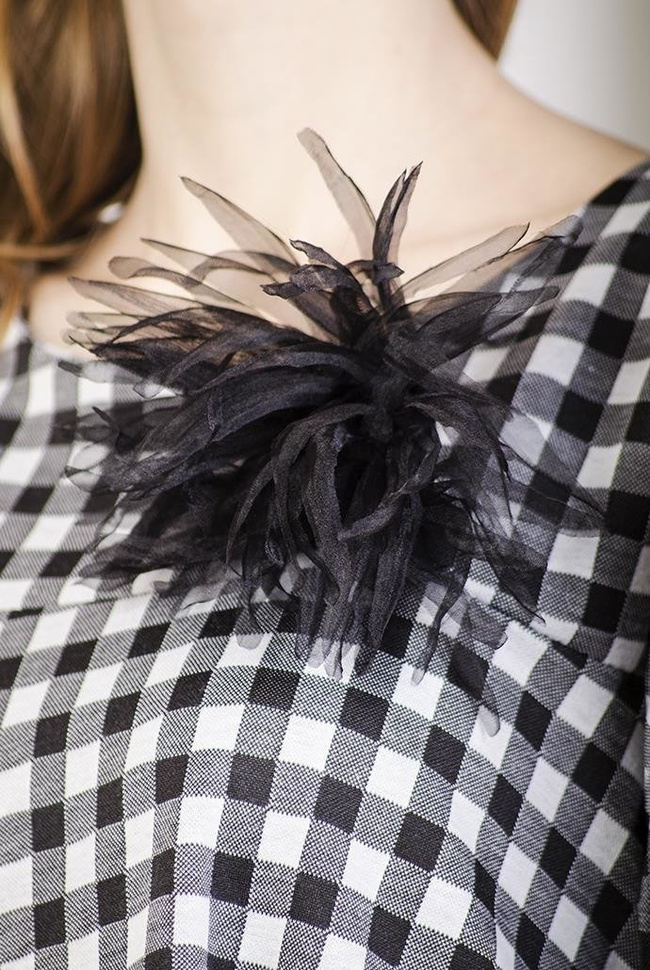 Rozkloszowana biało-czarna sukienka w kratę z broszką