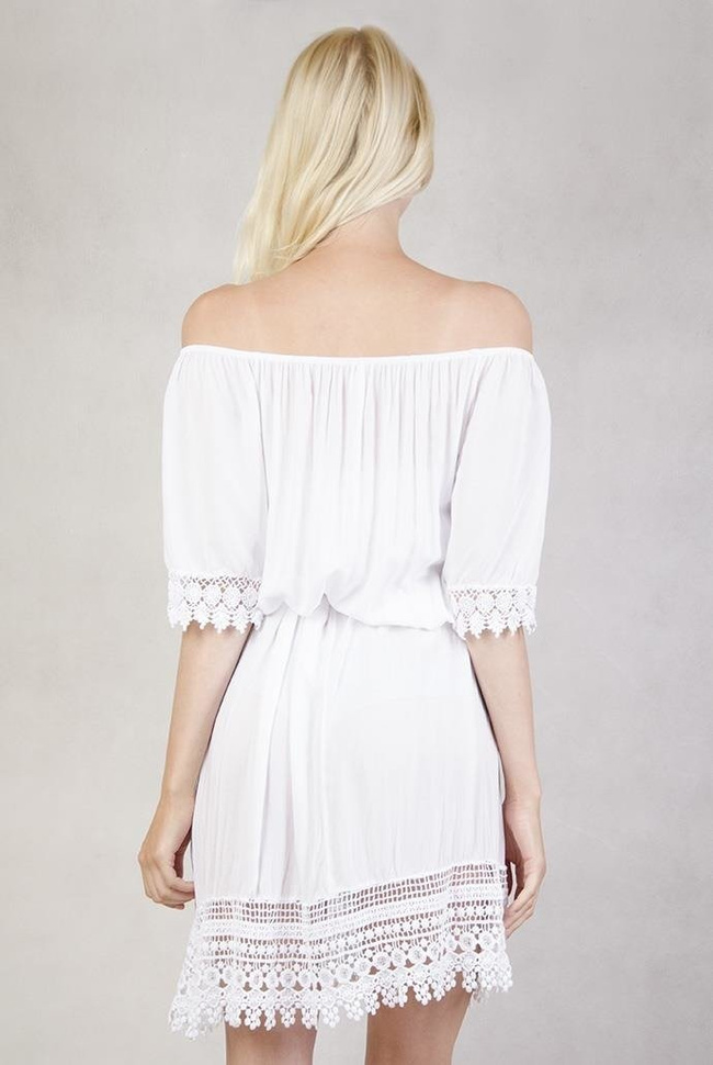 Biała sukienka z koronką przy rękawach.
