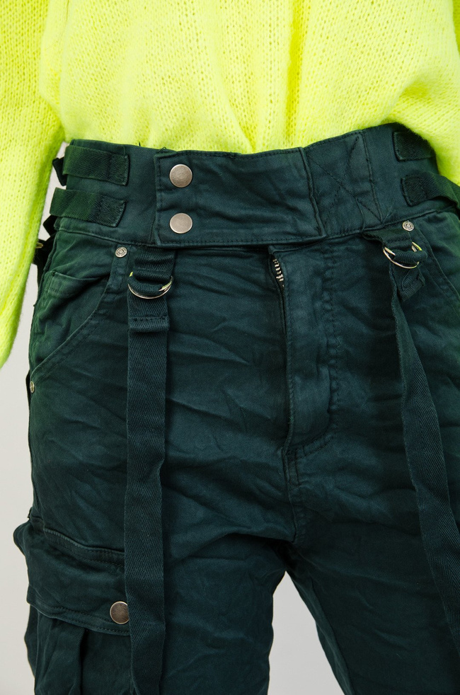 Zielone joggery z kieszeniami oraz szelkami.