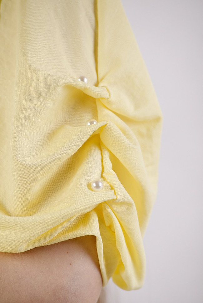 Żółta bluzka z wycięciem na plecach oraz koralikami na ramionach