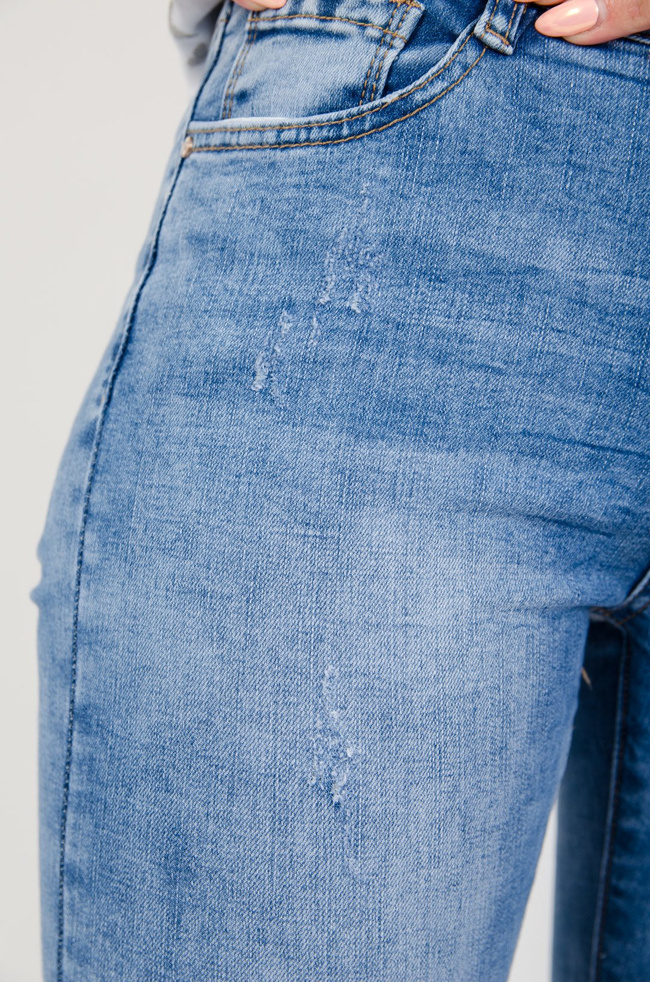 Jasne spodnie jeansowe z delikatnymi przetarciami