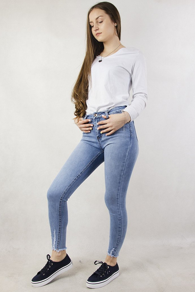 Jasne spodnie jeansowe z szarpaniem przy nogawce