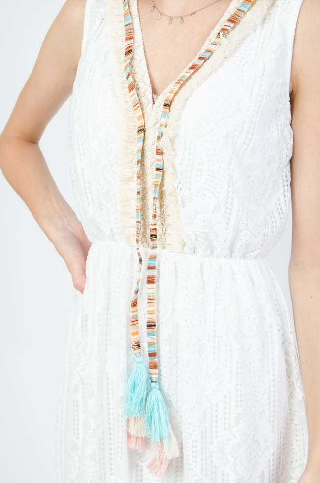 Biała koronkowa sukienka z gumką w pasie oraz beżowymi ozdobami