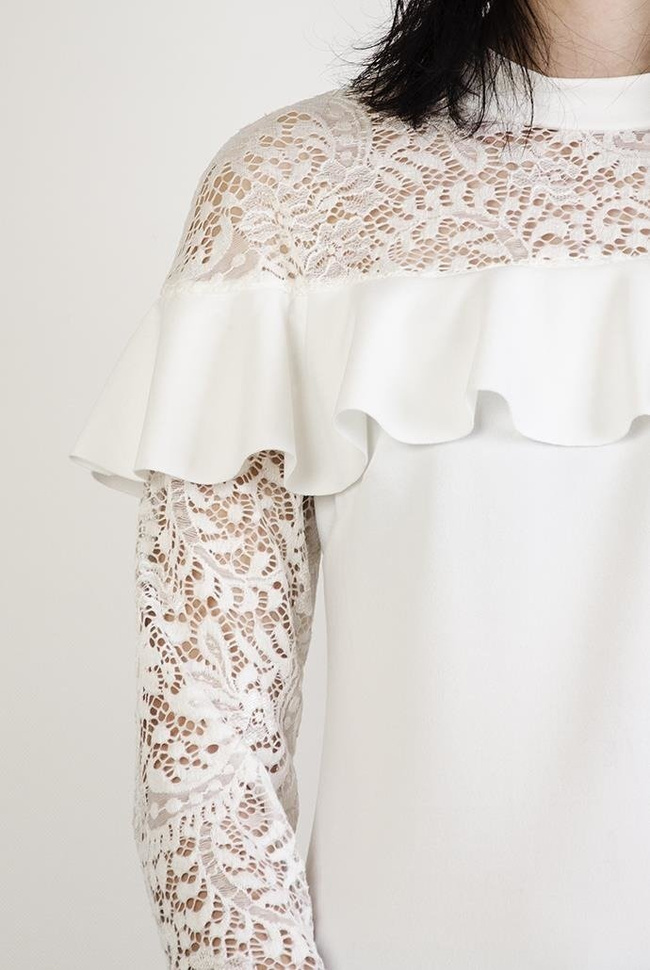 Biała bluzka z koronkowymi wstawkami i falbanką w dekolcie