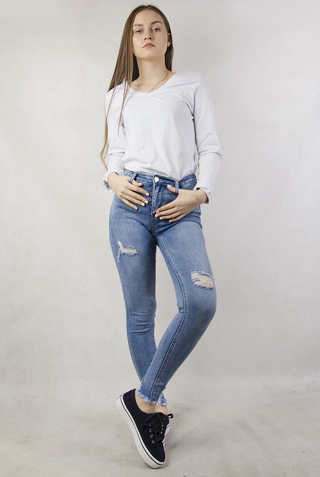 Jasne spodnie jeansowe z dziurami oraz przetarciami