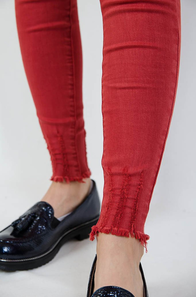 Czerwone spodnie jeansowe z szarpaniami na dole nogawki