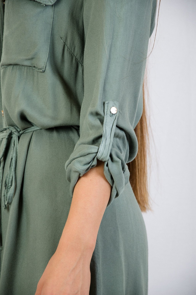 Zielona sukienka zapinana na złote guziki wiązana w pasie 