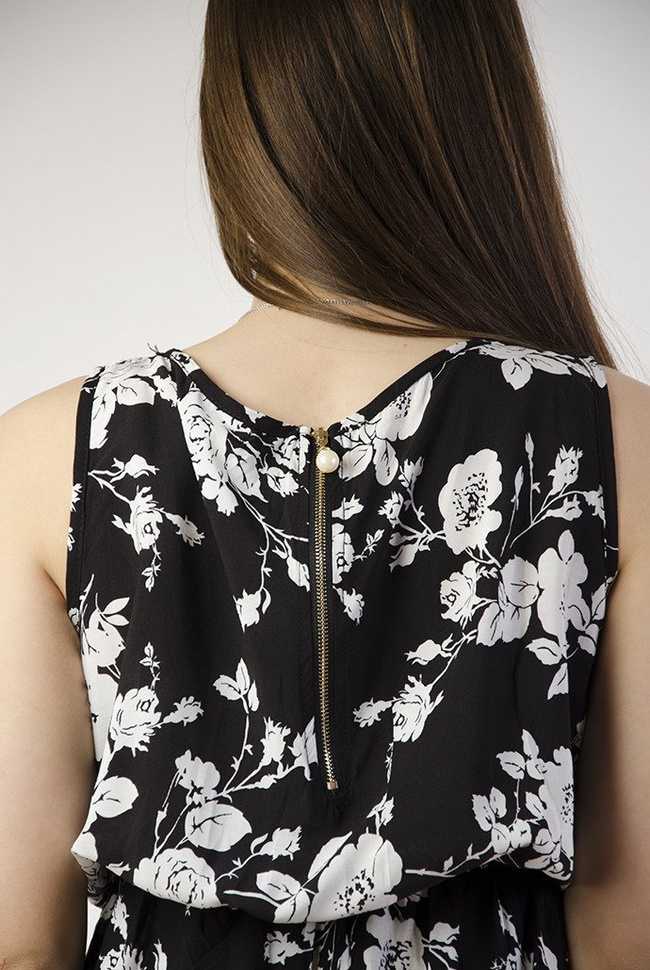 Czarna sukienka w białe kwiaty z zamkiem z tyłu, zakończonym perłą.