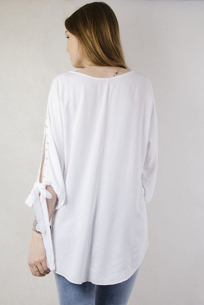 Biała asymetryczna bluzka z wiązaniem przy rękawie oraz perełkami