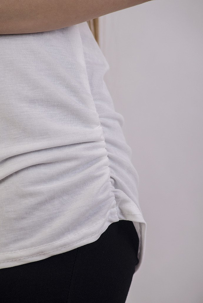 Biała bluzka z wycięciem na plecach oraz koralikami na ramionach