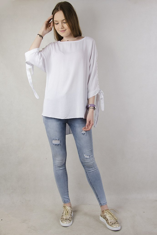 Biała asymetryczna bluzka z wiązaniem przy rękawie oraz perełkami