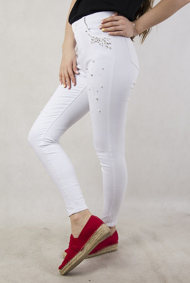 Białe spodnie z przetarciami oraz koralikami