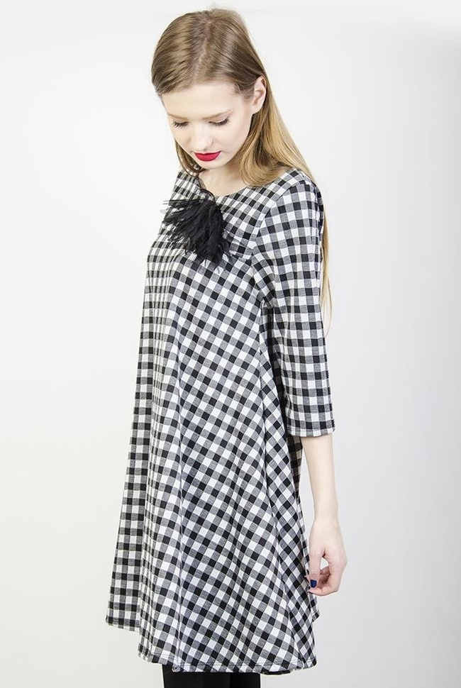 Rozkloszowana biało-czarna sukienka w kratę z broszką
