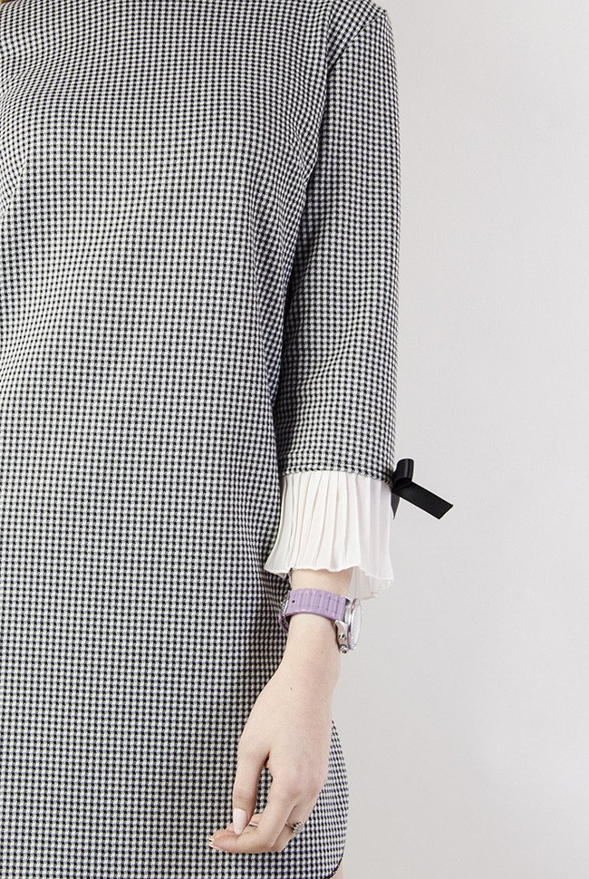 Asymetryczna sukienka w pepitkę z plisowaniem przy rękawie.