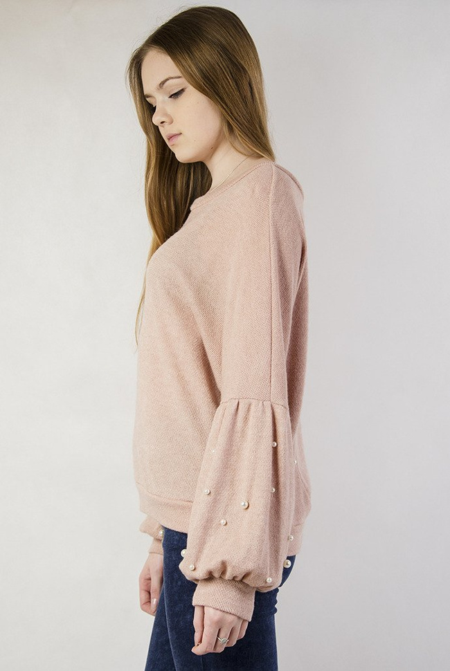 Jasnoróżowy sweterek z bufiastymi rękawami oraz perełkami