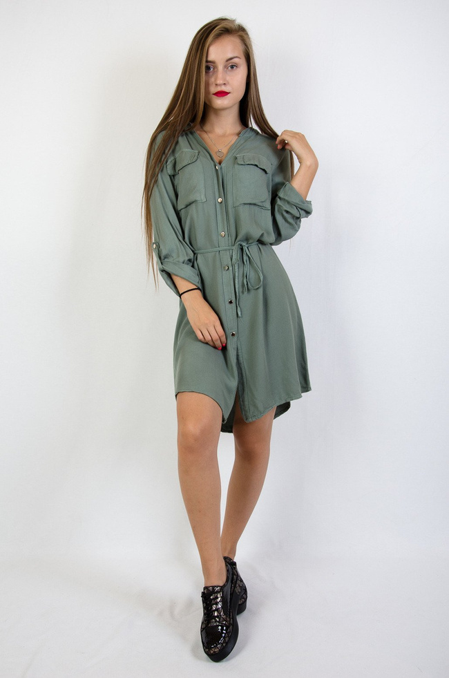 Zielona sukienka zapinana na złote guziki wiązana w pasie 