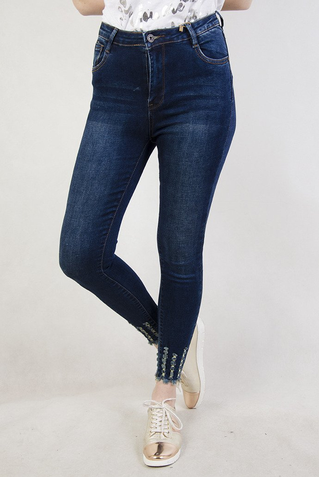 Ciemne spodnie jeansowe z wysokim stanem oraz szarpaniami przy nogawce