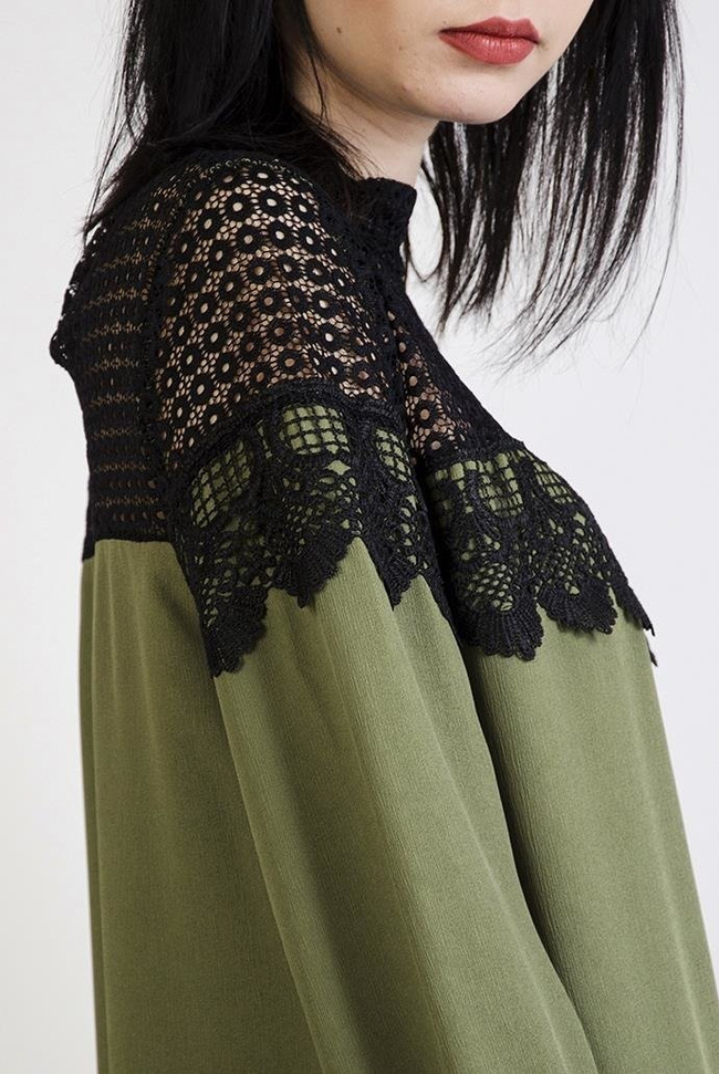 Zielona bluzka z kulkami przy rękawach i ażurowymi wstawkami