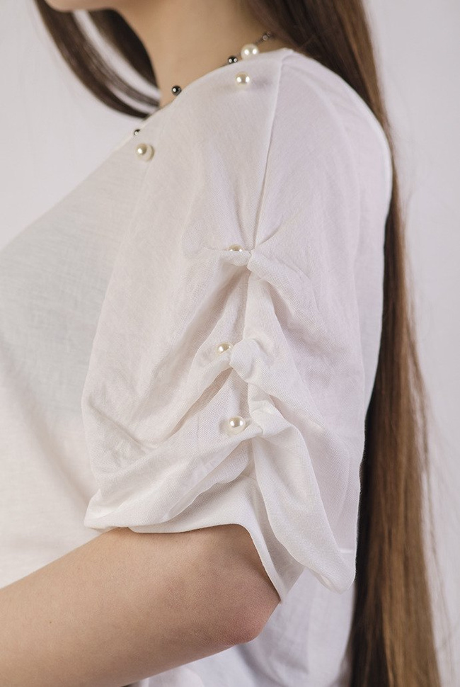 Biała bluzka z wycięciem na plecach oraz koralikami na ramionach