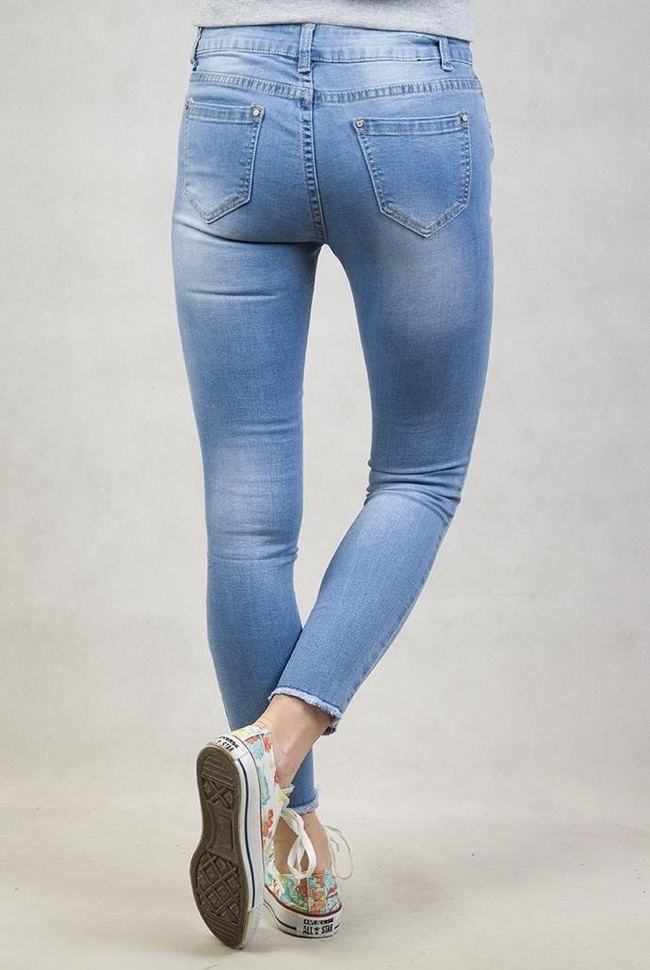 Spodnie jeansowe z dziurami na kolanach oraz frędzlami przy nogawkach