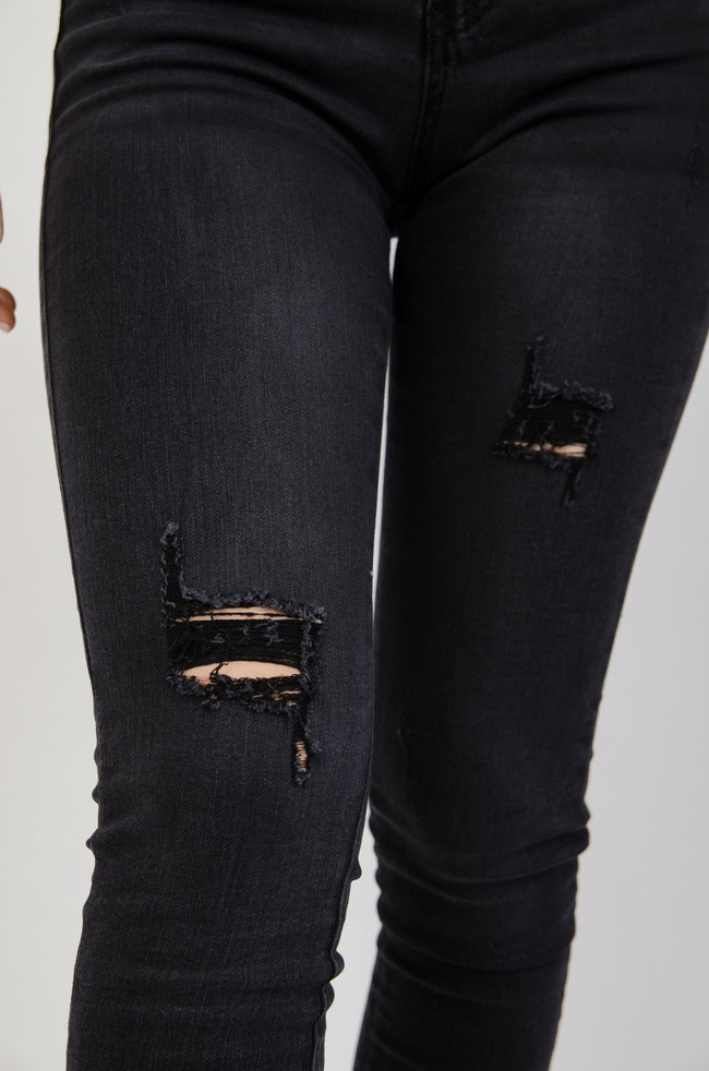 Ciemne spodnie jeansowe z przetarciami
