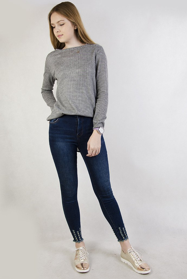 Ciemne spodnie jeansowe z wysokim stanem oraz szarpaniami przy nogawce