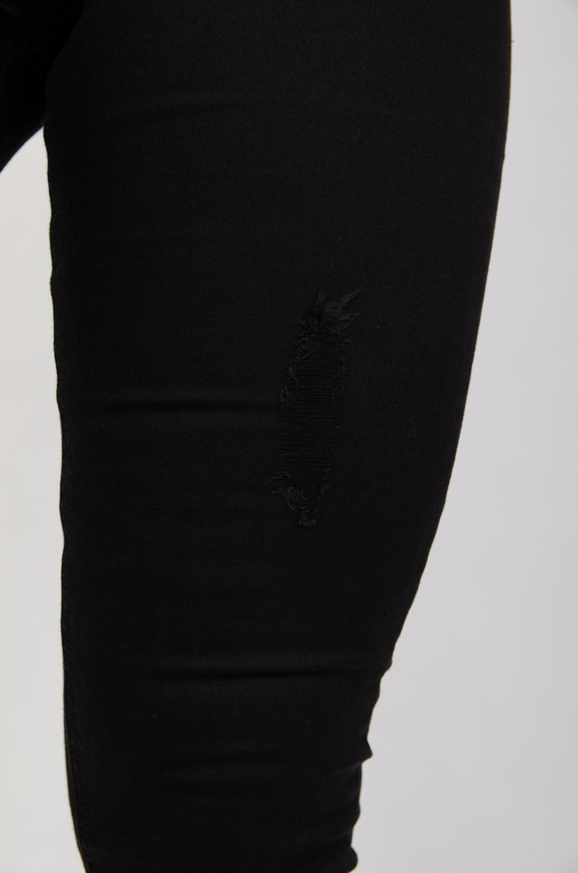 Czarne spodnie jeansowe z przetarciami zapinane na guziki