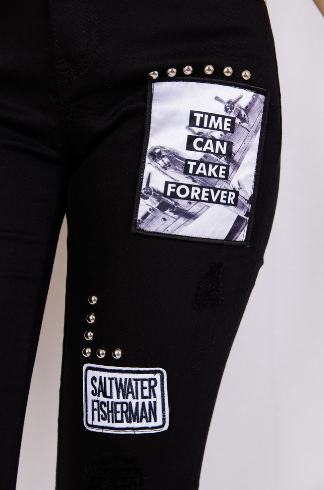 Czarne spodnie jeansowe z naszywkami i dziurami